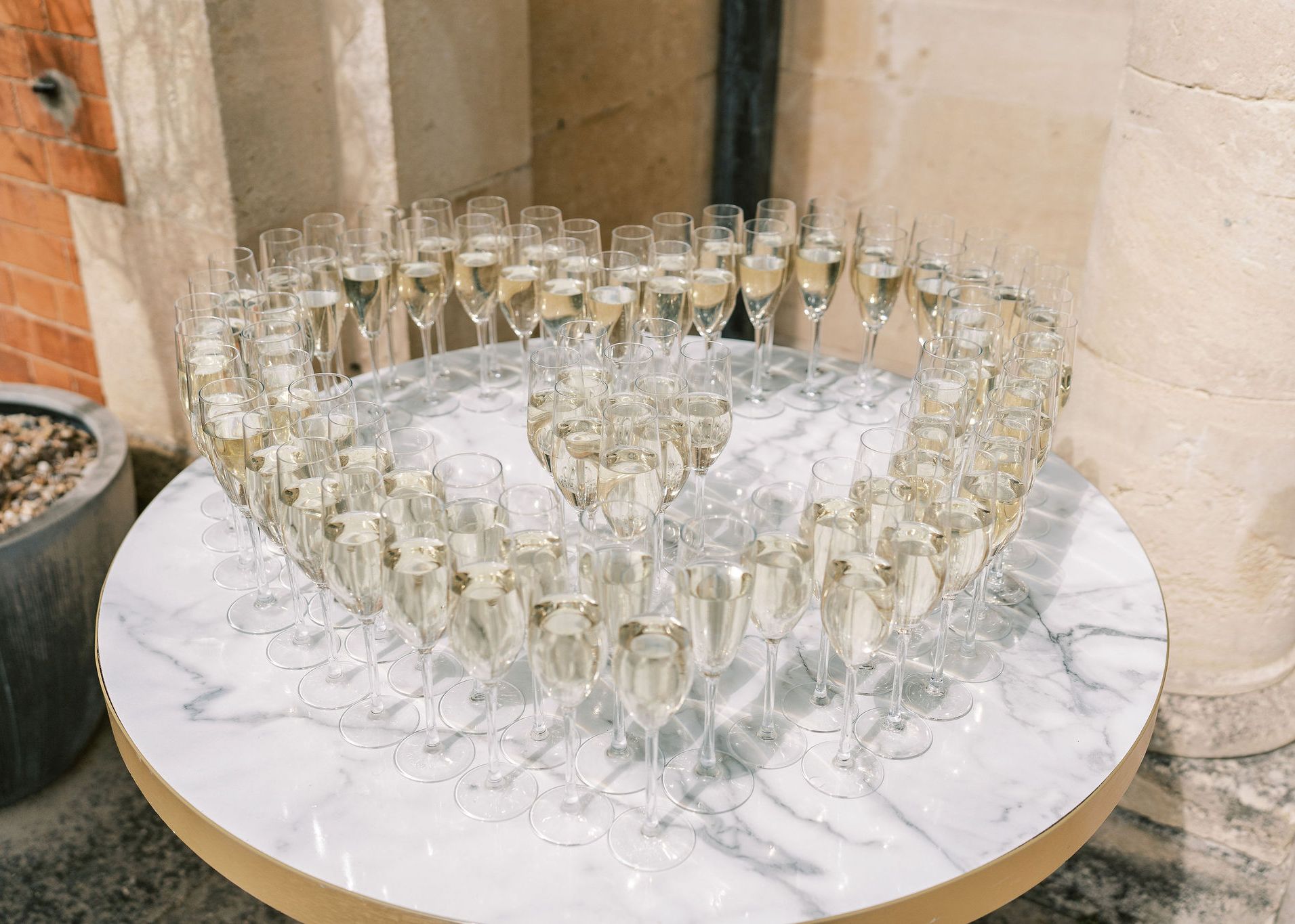 Champagne glasses arranged in a heart shape on a marble table