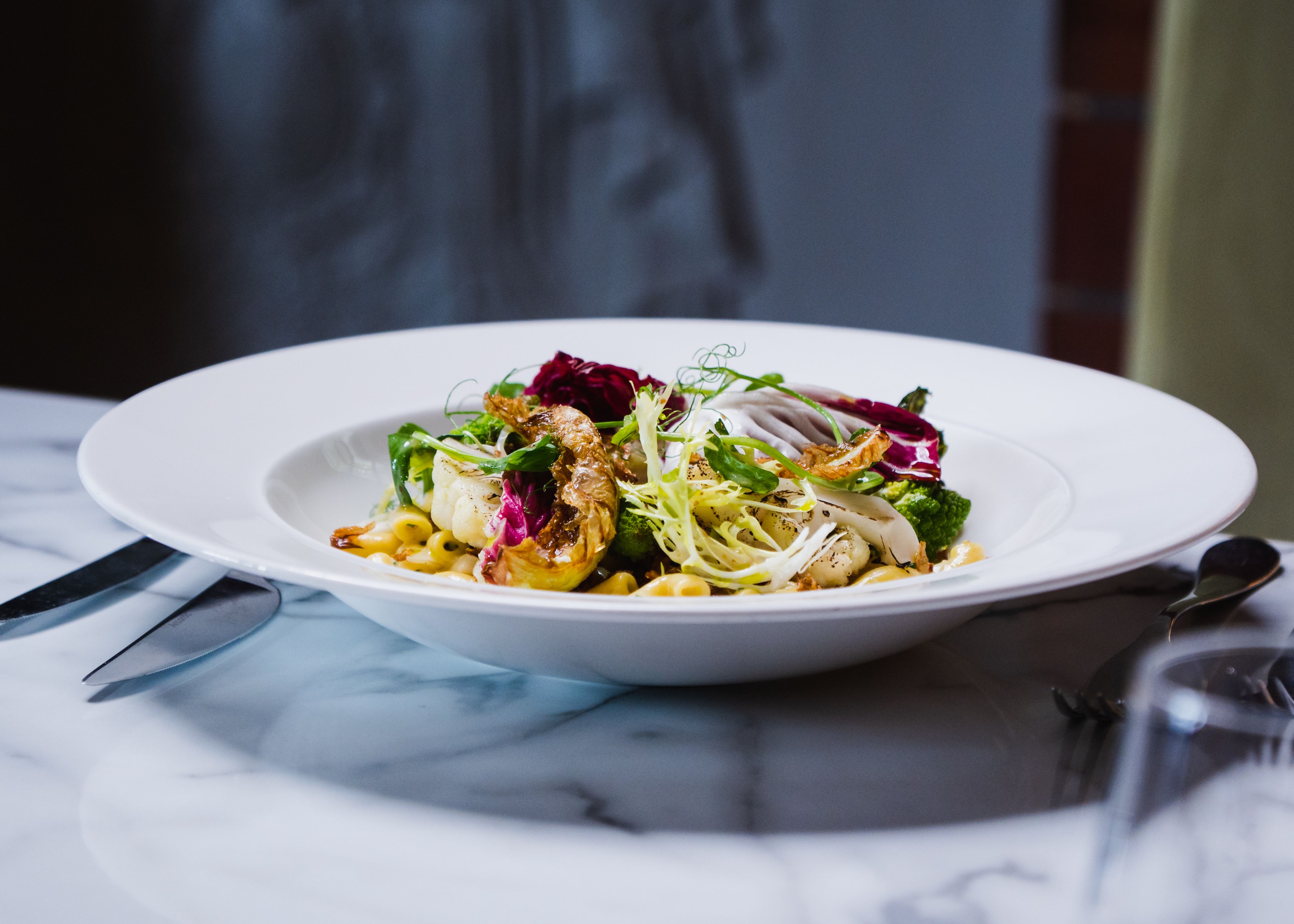 Bowl of pasta with cauliflower and a garden salad