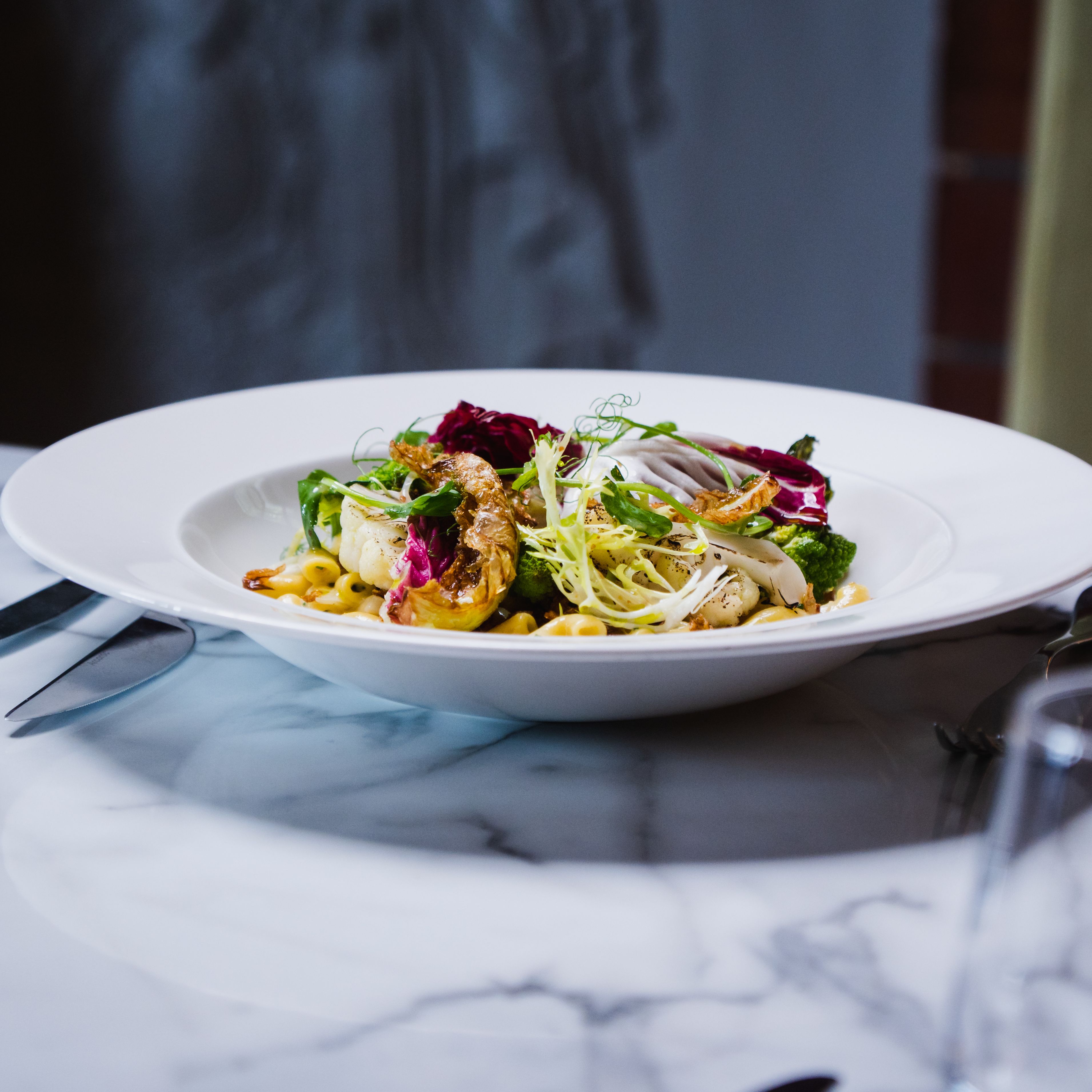 Bowl of pasta with cauliflower and a garden salad