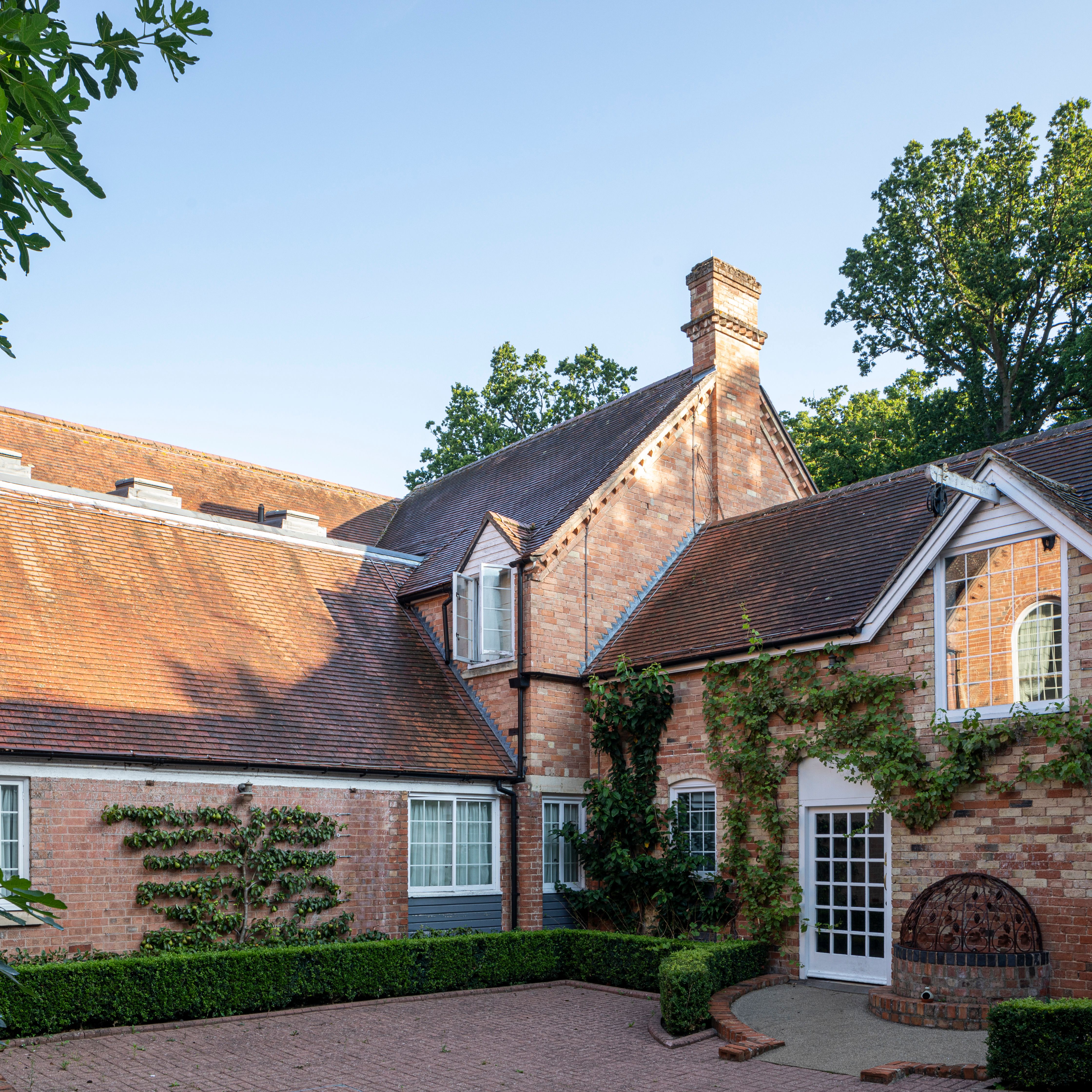 Traditional brick house with pitched roofs and climbing plants