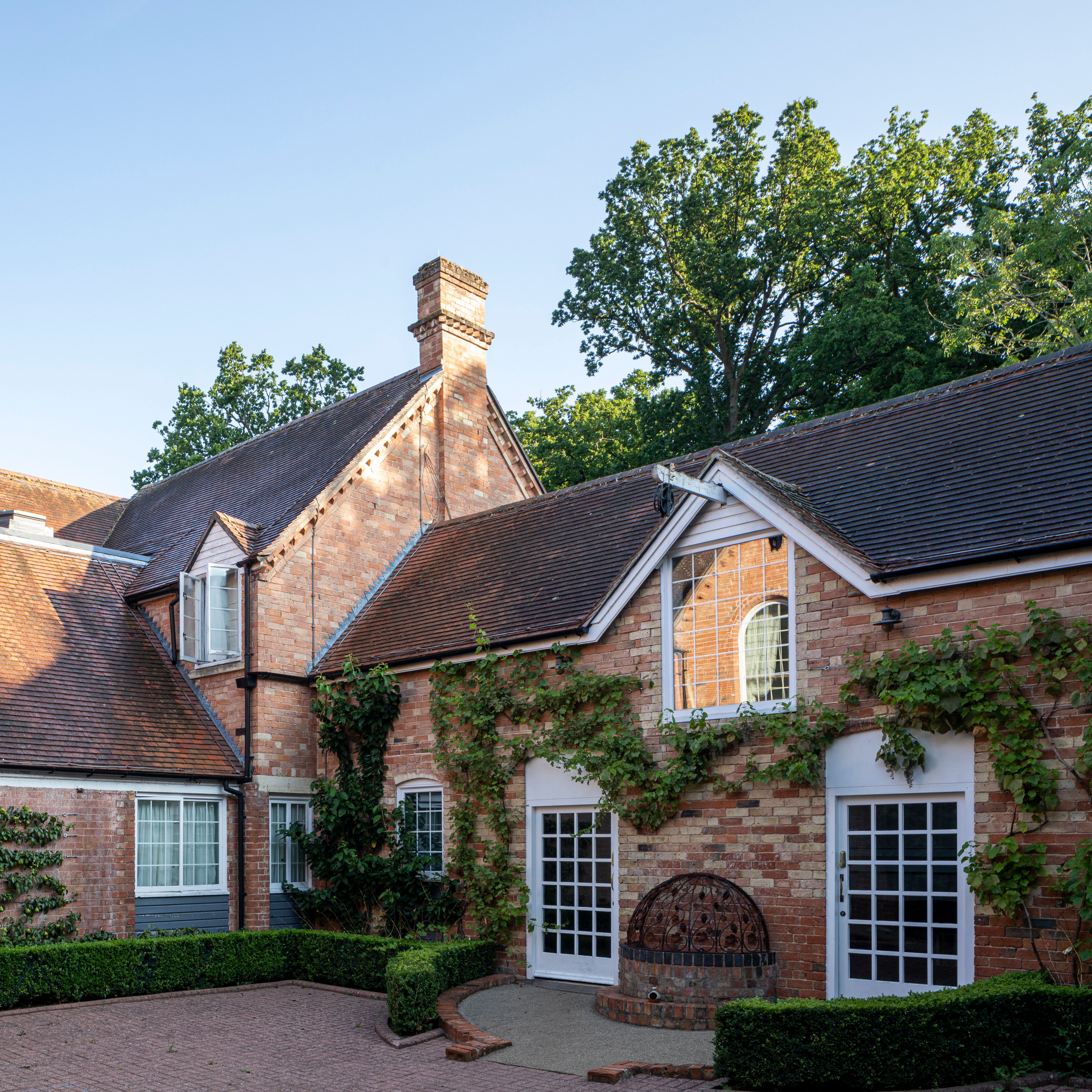 Traditional brick house with pitched roofs and climbing plants