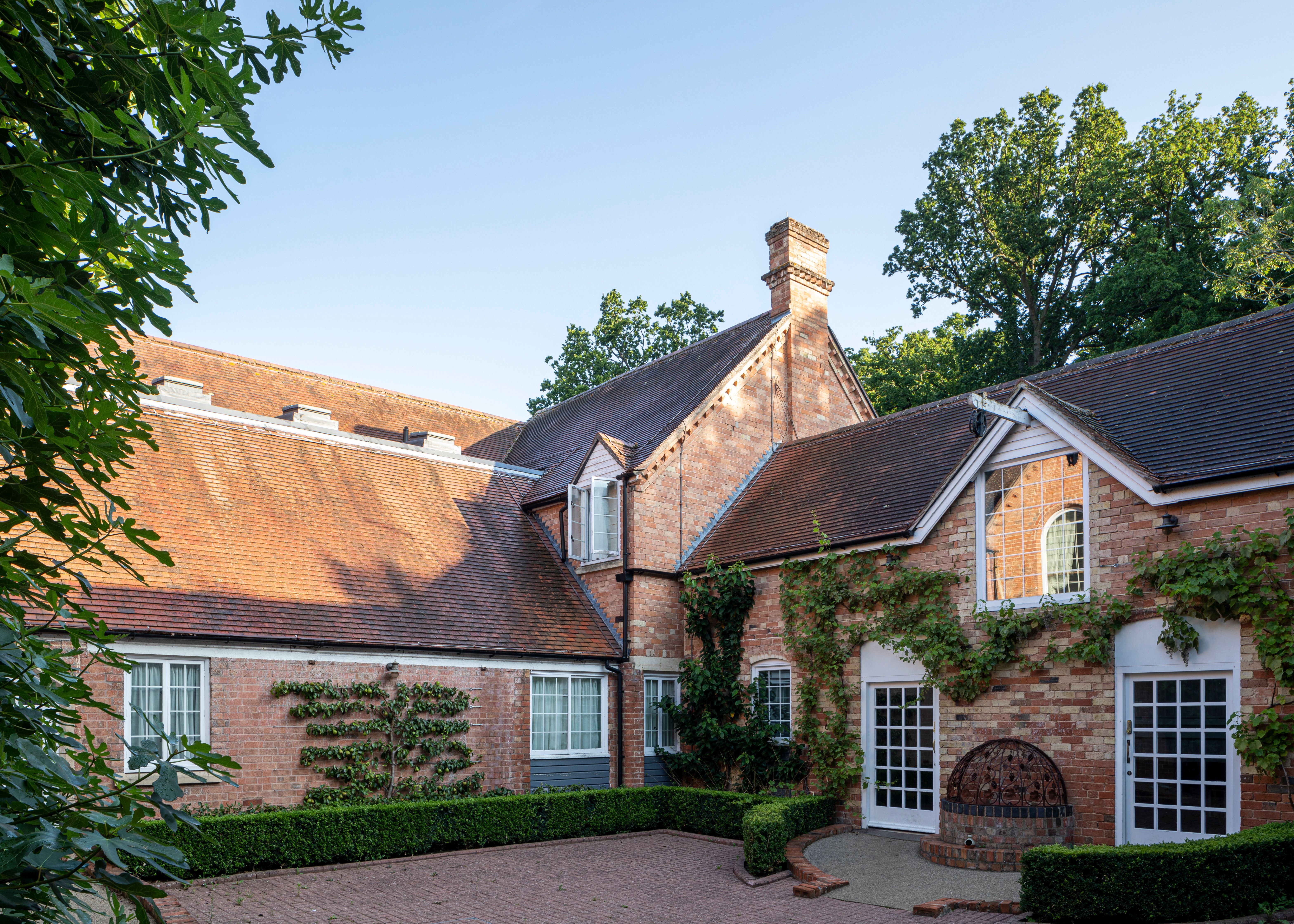 Traditional brick house with pitched roofs and climbing plants