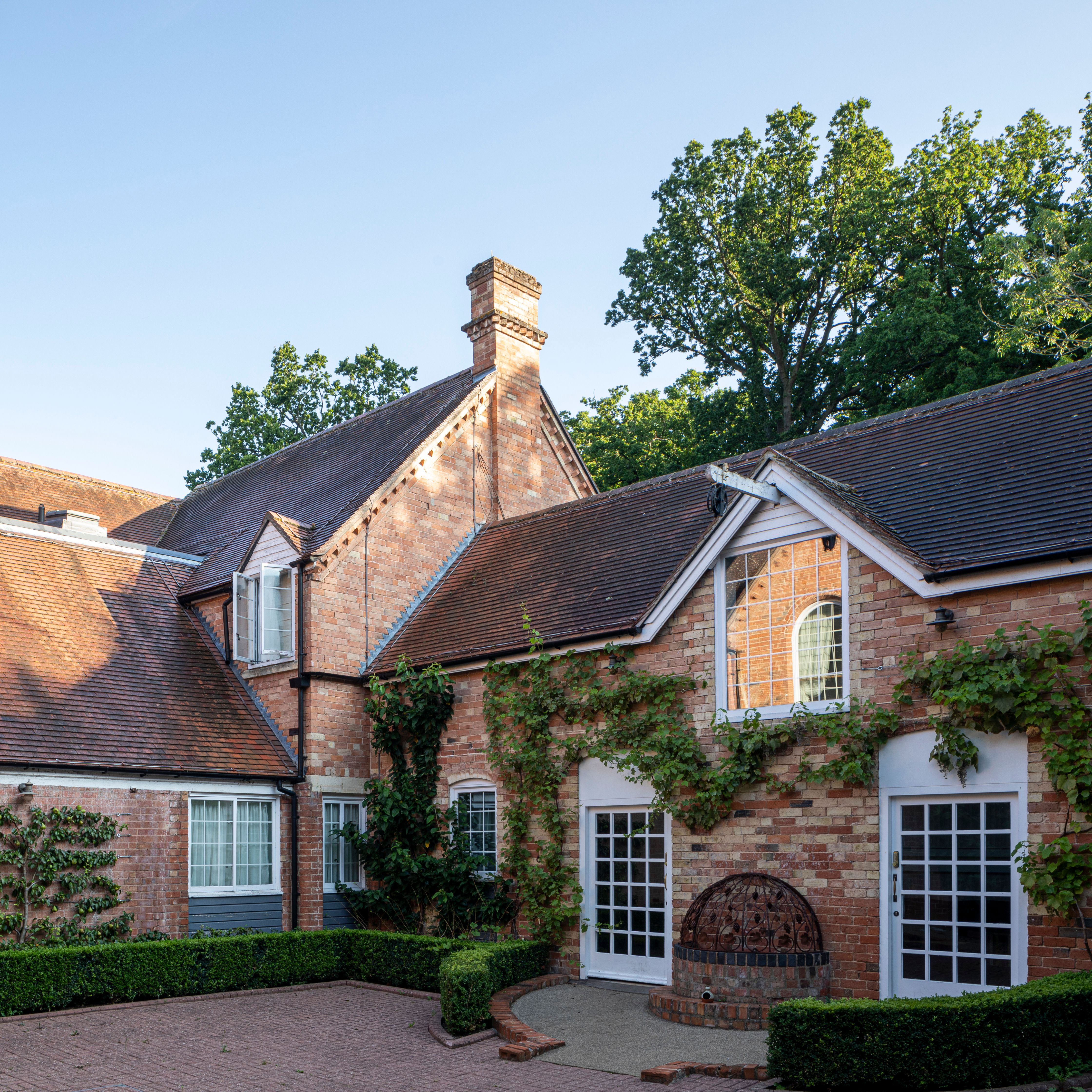 Traditional brick house with pitched roofs and climbing plants