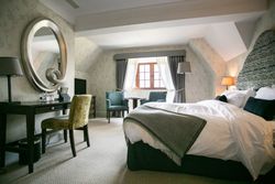 Large bedroom with big round mirror